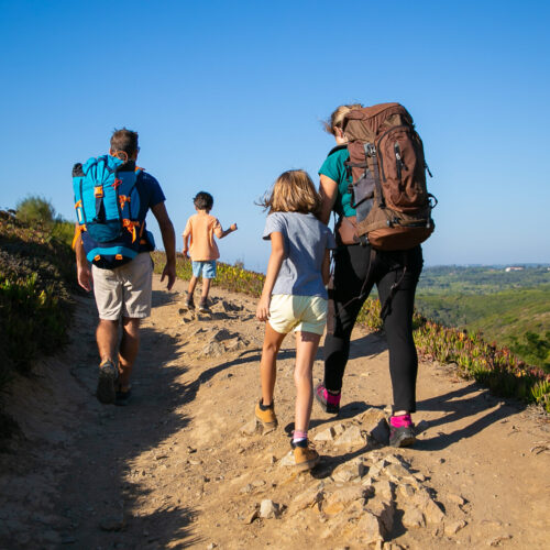Family of travelers with backpacks walking on track Family Fun Package